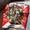 Dettaglio di elegante foulard di seta con motivi floreali e frutti su divano scuro - 70*70cm / Rosso