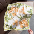 Dettaglio del foulard di seta a fiori arancioni con bordo giallo su divano in pelle - 70x70cm / Bianco