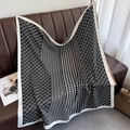 Detailed close-up of a large black and white houndstooth silk scarf on a brown sofa - Ring Houndstooth Black (XW-169-Black)