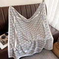 Detail of striped silk twill scarf draped over leather sofa with fashion accessories - White