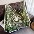 Dettaglio foulard in seta con stampa rose verdi drappeggiato su divano con accessori - Verde