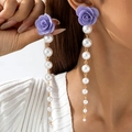 Detail van paarse stoffen rozenoorbel met verloop parels en elegante gouden kettingkwast - Paars