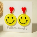 Close-up of cute cartoon yellow smiley face earrings with red hearts on display card - Standard Winking Smile Style (31333)