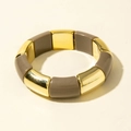 Dettaglio di segmenti in metallo dorato e resina taupe di un bracciale elastico boho - Talpa (31179-bra-lig bro-EP)