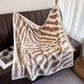 Sciarpa di seta con stampa zebra marrone drappeggiata su un divano in pelle di lusso - Cachi