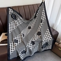 Detail of a black and white check scarf with camellia print draped over a leather sofa - 90*90cm / Black Edge (XW-173)