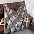 Detailed close-up of houndstooth and camellia print silk scarf on a leather surface - 90*90cm / Khaki Edge (XW-173)