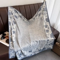 Detailed view of large square silk scarf with dark floral borders on a leather sofa - Gray (XW-175)