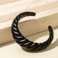 Nahaufnahme von mattem schwarzen gewundenen Armreif auf beigem Schmuckständer - Wellen-Spiral-Design (31196) / Mattschwarz