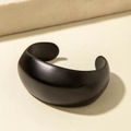 Bracelet manchette large noir mat au design géométrique ouvert sur un support texturé - Style Large Minimaliste (31197) / Noir mat