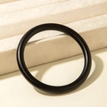 Detail view of a minimalist black matte acrylic bangle on a beige velvet jewelry display - Round Thin Style (31198) / Matte Black