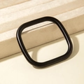 Macro view of minimalist matte black geometric square bangle on beige velvet stand - Square Frame Style (31200) / Matte Black
