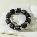 Detailed macro view of black acrylic beads with silver accents on a white rock texture - Wood Grain Texture Black Silver Style (31225-bra-black-EP)