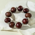 Close-up of beaded bracelet with dark brown beads and silver accents on white stone - Large Diameter Dark Brown Beads (31227-bra-brown-EP)