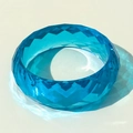 Detail of faceted blue transparent resin bracelet with geometric diamond-cut texture - Blue
