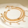 Gold layered chain jewelry set with heart-shaped rhinestones on a white ceramic plate - Heart Rhinestone Long Bar Style (31008-ank-G-EP)