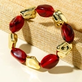 Detail of bohemian stretch bracelet with marbled red resin and faceted gold beads - Dark Red Marble Pattern Bead Bracelet (31598)