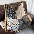 Detailansicht eines Seidentuchs mit Paisley-Muster drapiert auf einem Ledersofa - 90*90cm / Schwarz (DM-14)