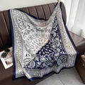 Detail of navy paisley silk scarf draped on a leather sofa with vintage accessories - Navy Blue