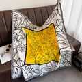 Close-up of artistic floral print silk scarf draped over a brown leather sofa - Yellow