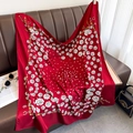 Elegant 90cm red silk scarf with rose and gold chain print on a brown leather sofa - Red