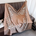 Detail of silk-like scarf with floral prints and chain patterns draped over a sofa - Dusty Pink