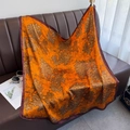 Luxury 90cm faux silk square scarf featuring orange floral patterns on a leather sofa - Orange / 90cm X 90cm