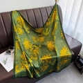 Detailed drape of dark green silk-like scarf with large yellow floral prints on leather sofa - Green / 90cm X 90cm