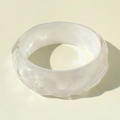 Detail of white irregular wave-patterned resin bangle with iridescent shimmering finish - White