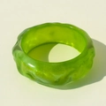 Detalle que muestra la textura ondulada y el acabado brillante del brazalete de resina verde - Cian