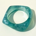 Vista macro de pulsera de resina verde translúcida con bordes suaves y pulidos - Cian