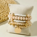 Detailansicht böhmisches Armband-Set auf Schmuckkissen mit goldenem Münzanhänger - Weiß Rosa Gold Harz Heishi Anhänger 5-teiliges Set (31098-bra-apr-EP)