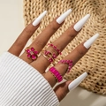 Detail of 5-piece gold ring set with pink gemstones and butterfly floral designs - Rose Red