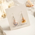 Detail of seashell drop earrings with gradient colors on a beach-themed display - Asymmetric Two-Color Gradient Shell Style (29368-6)