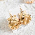 Detail of bohemian gold scallop shell earrings with white pearls on a sandy beach - Pearl Inlay Seashell Style (29421-2)