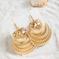 Détail de boucles d'oreilles bohèmes en forme de pétoncle doré sur fond de sable blanc fin - Grand Style Coquille Saint-Jacques Vintage (29421-3)