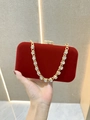 Close-up of red velvet evening clutch featuring gold diamond-encrusted chain and luxury lock - Red
