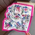 Detailstruktur eines seidigen quadratischen Blumen-Schals mit rosa Rand auf Lederhintergrund - Rosa Rand Blumen