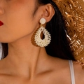 Macro detail of handmade raffia woven teardrop earrings with sparkling rhinestones - Cream White