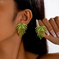 Detailed close-up of handmade green woven palm leaf earrings with golden metal edges - Emerald Green