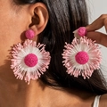 Close-up of handmade raffia flower earrings in vibrant pink and rose tones on a model - Pink Rose Block
