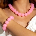Close-up of pink acrylic beaded necklace and bracelet set worn on a white silk outfit - Pink(27326-Set)