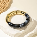 Detail of chunky resin bracelet with black marble texture and gold metal segments - Spliced Round Style (29808-G) / Black