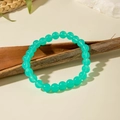 Dettaglio ravvicinato di un bracciale con perline in acrilico verde menta su legno - Verde Scuro