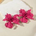 Macro shot of rose red matte flower earrings with layered petals on stone stand - Rose Red