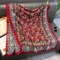 Detailed view of red paisley print scarf draped on a sofa with fashion accessories - Red (A-548)