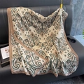 Beige paisley print lightweight cotton-linen scarf draped over a sofa for home decor - Khaki Edge