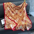 Detail of soft paisley pattern scarf with red borders draped over a sofa - Red Border