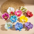 Flat lay of artificial orchid heads in 10 vivid colors on a natural woven mat background - 10-Color Set