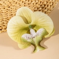 Detailed macro view of artificial yellow-green orchid flower head with realistic purple spots - Light Yellow Green